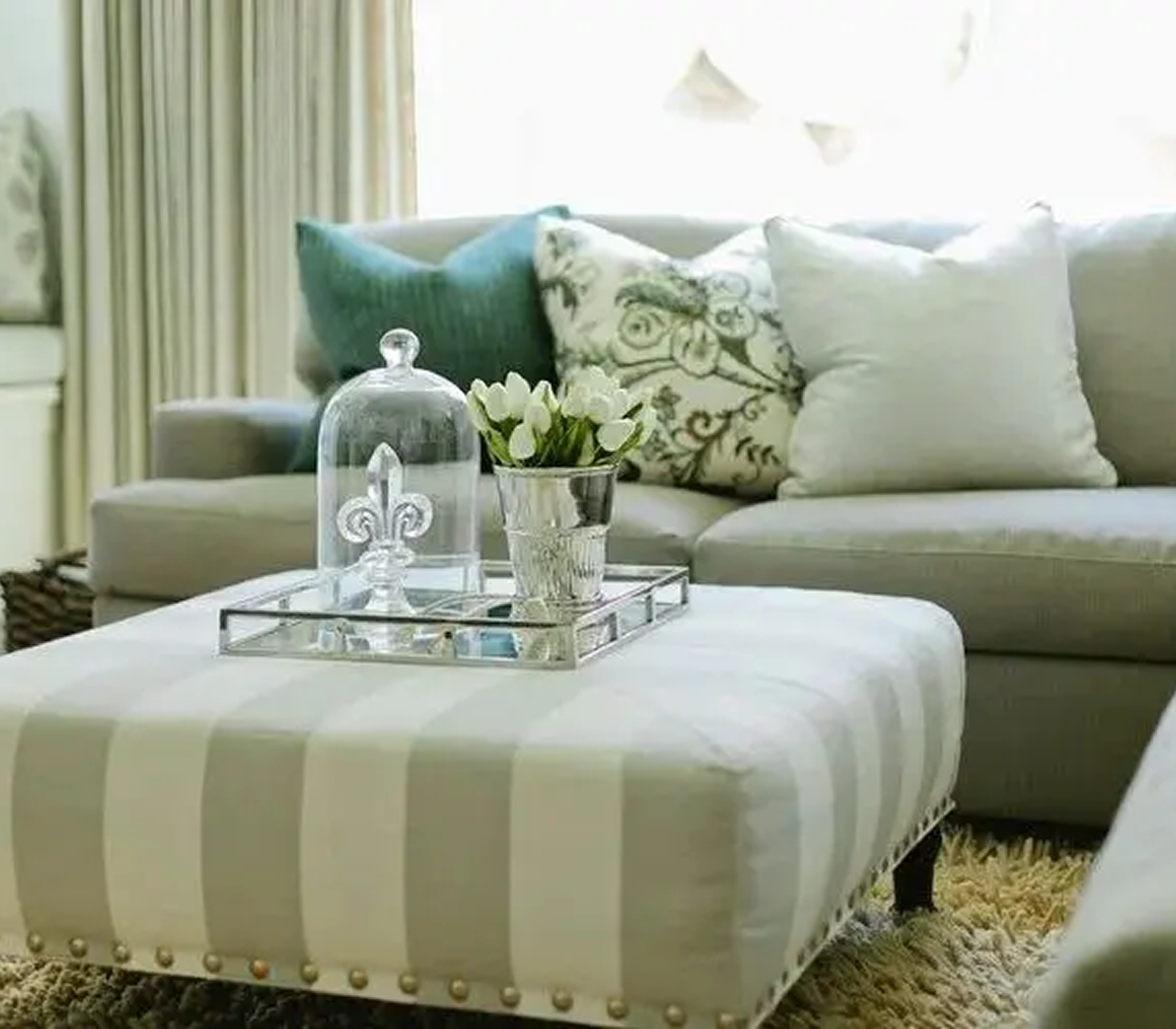 Elegant living room with decorative ottoman tray.